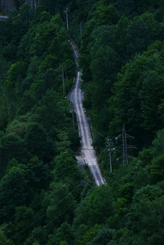 a steep mountain road with trees and sky