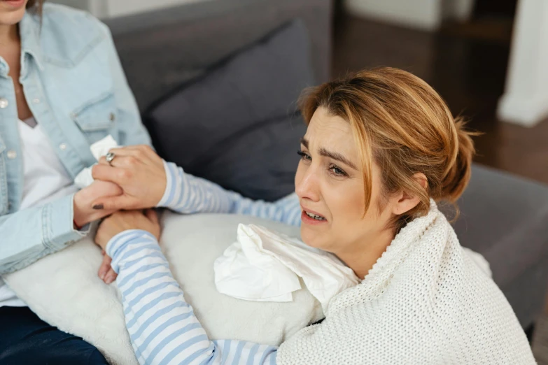 the woman is holding onto the child while it sits on her couch