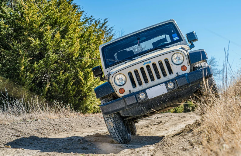 a jeep driving on a muddy road in the wilderness