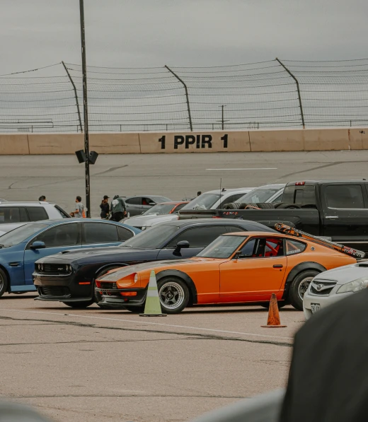 a row of sports cars parked on the side of a track