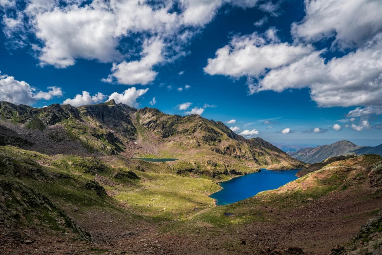 a hill side with a blue lake next to it