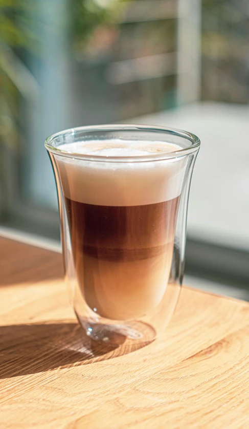 a cup of liquid sitting on a wooden table