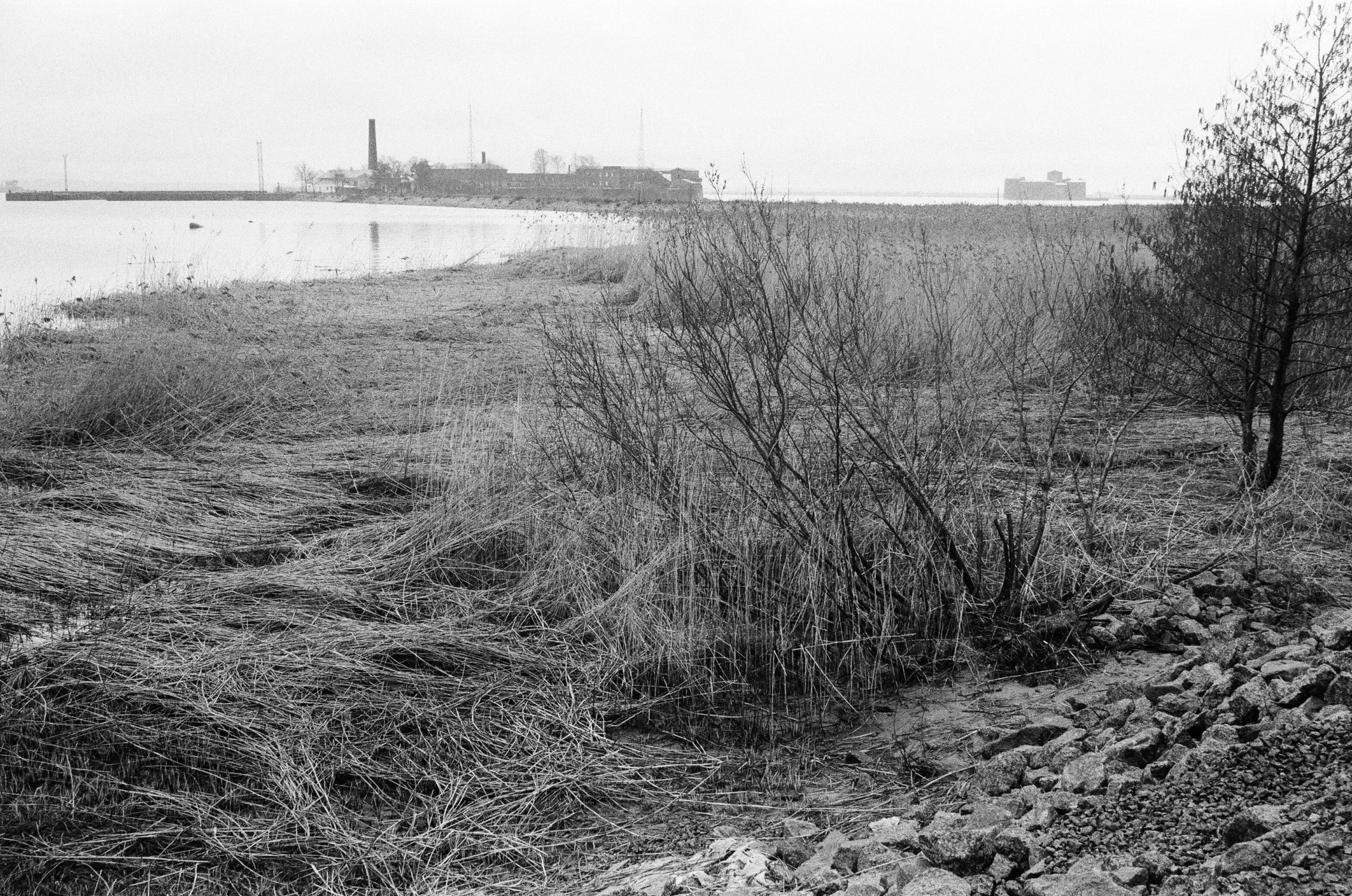 the river runs into a dry field near a large ship in the distance