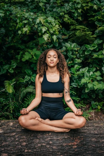 a young woman in black yoga wear meditating