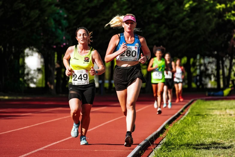 a group of people running down a track in a race