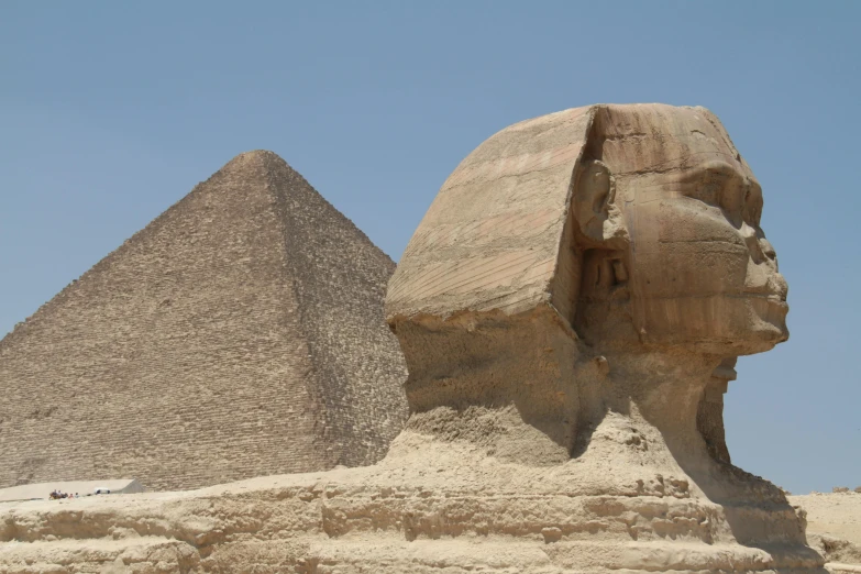 a large statue of an egyptian person next to the sphinx of a pharaoh