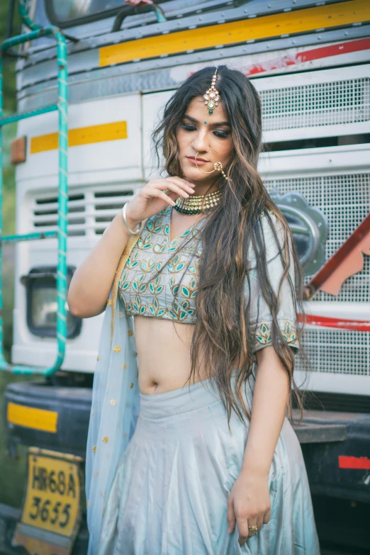 a beautiful woman in a skirt posing near a truck