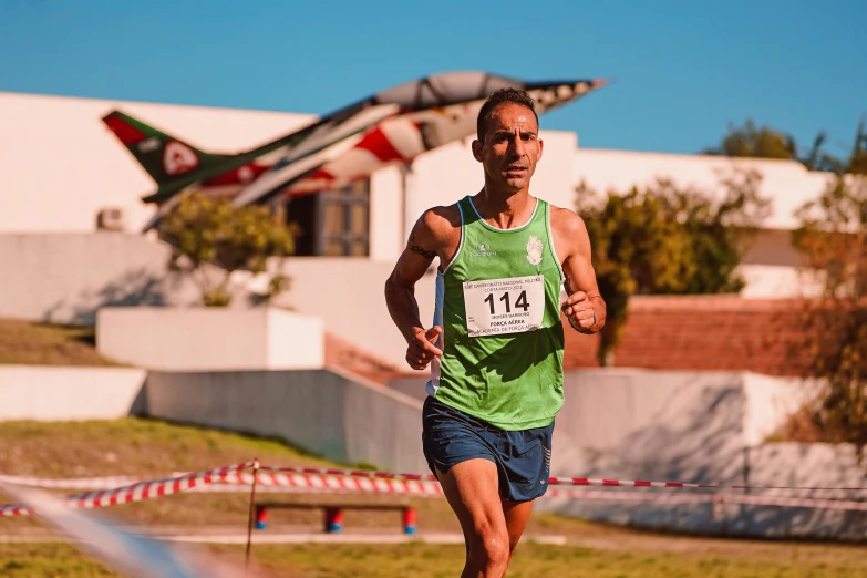 a man is running through a park while a plane flies overhead