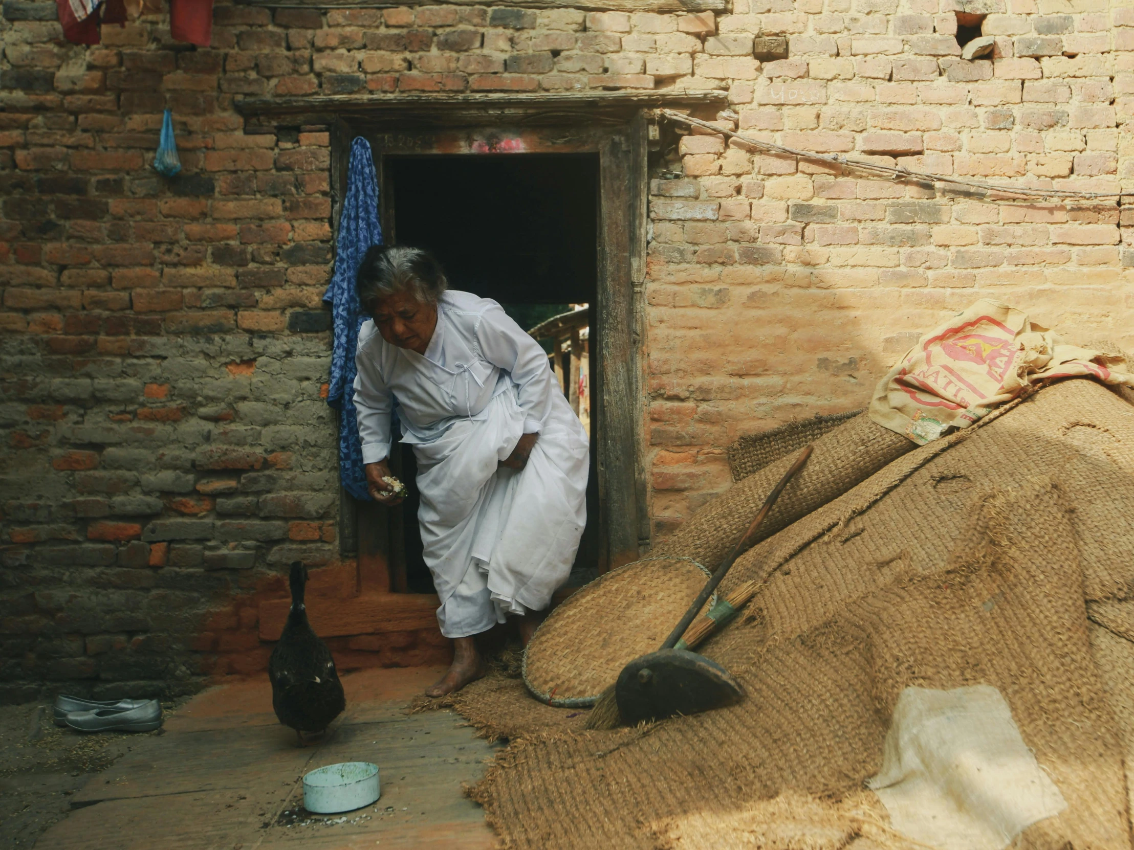 a person standing outside a doorway with a rug over it