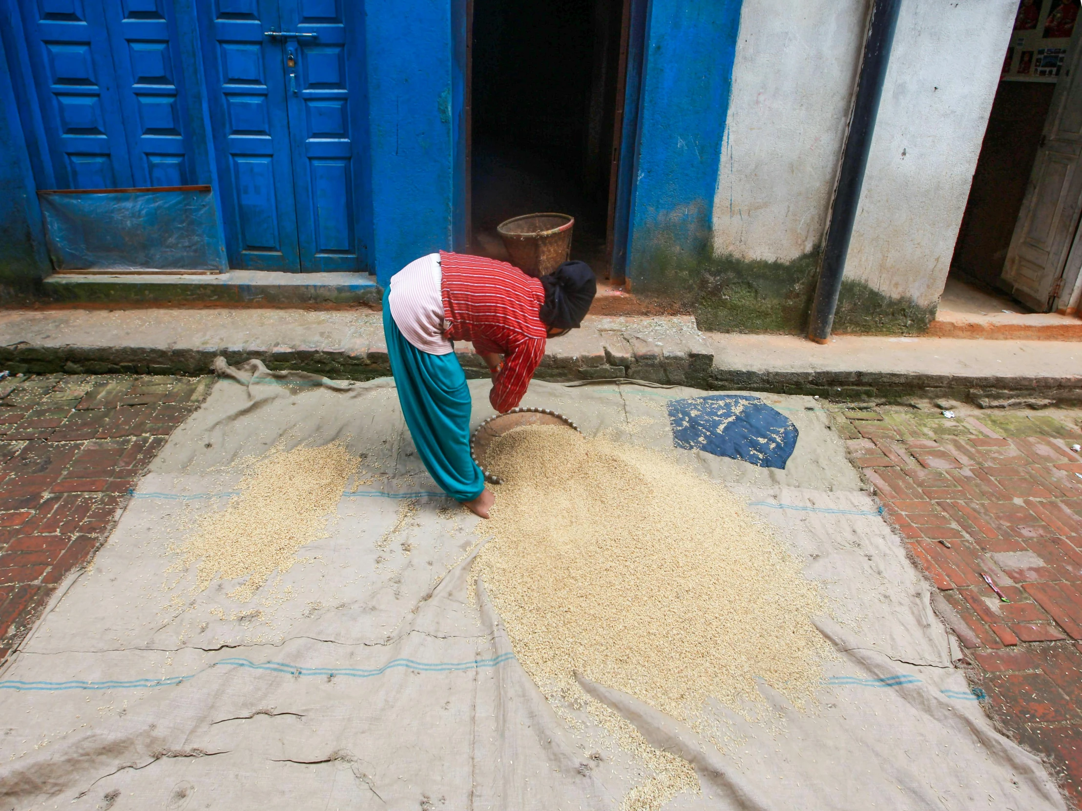 a man standing over sand on a street