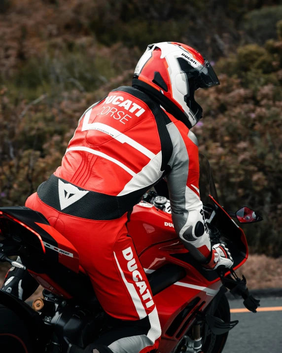 man in racing gear riding a red motorcycle