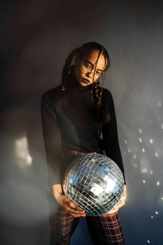 a woman in tights holding a disco ball