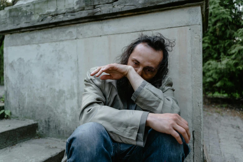 a man sitting on some stairs next to a cement building