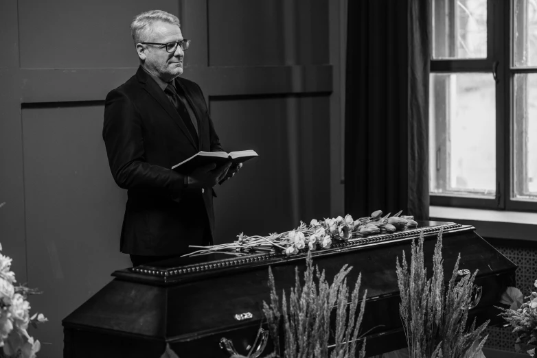 a man stands at the podium of a funeral service