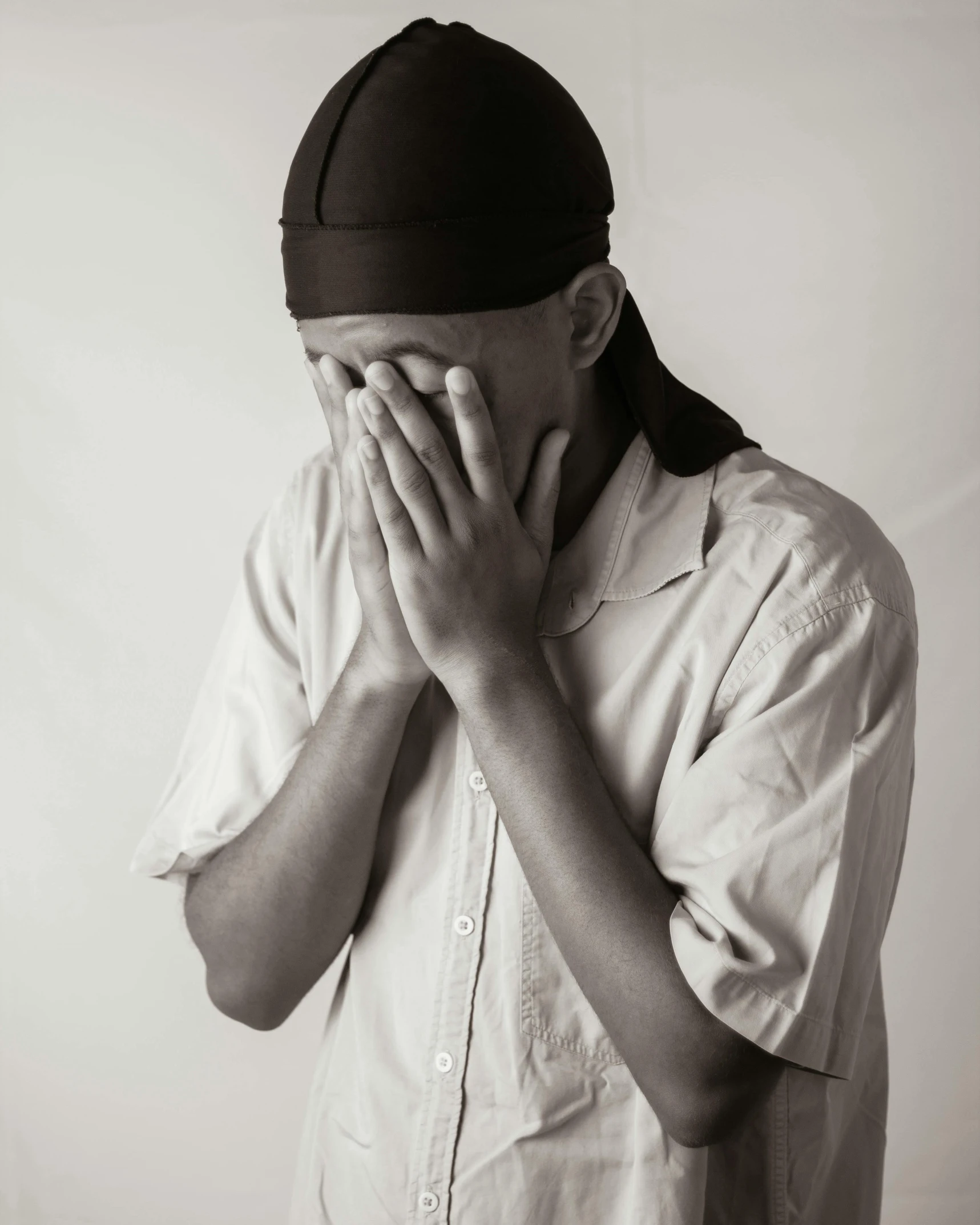 a man covering his eyes while standing