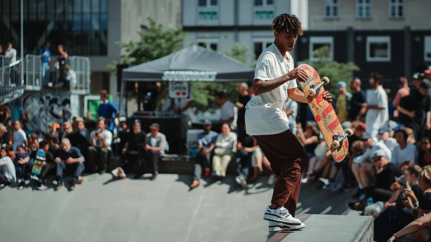 a skateboarder performing a trick on his skateboard while people are watching him