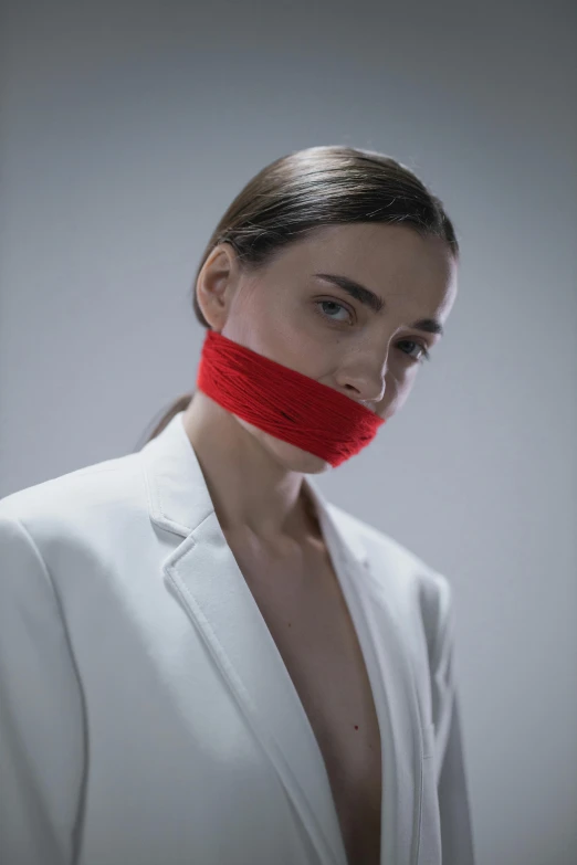 a woman is wearing a red band across her mouth