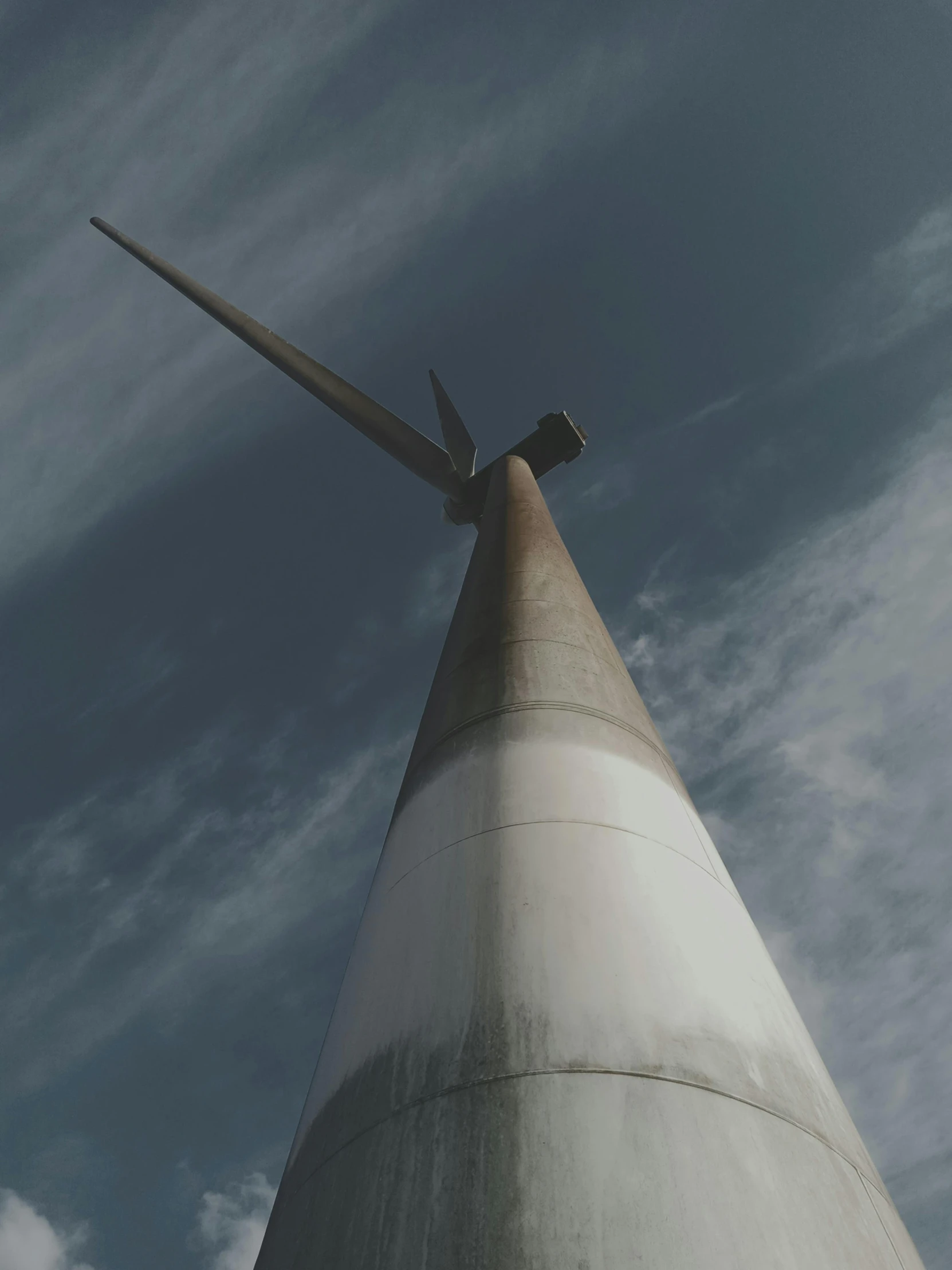 a very tall metal cone that is under a cloudy blue sky