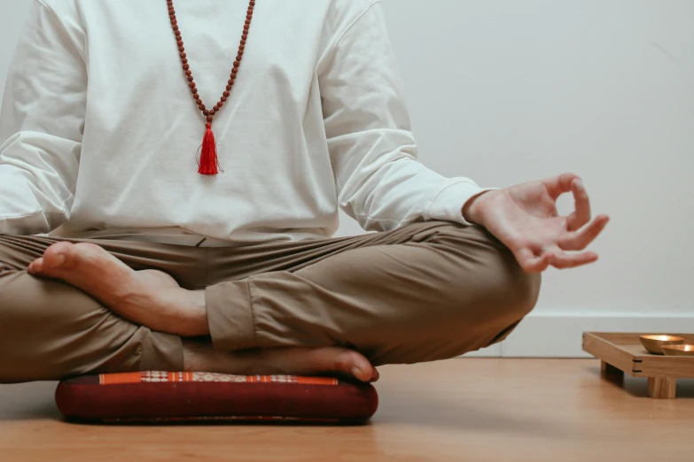 the man is meditating in the lotus position with his hands out