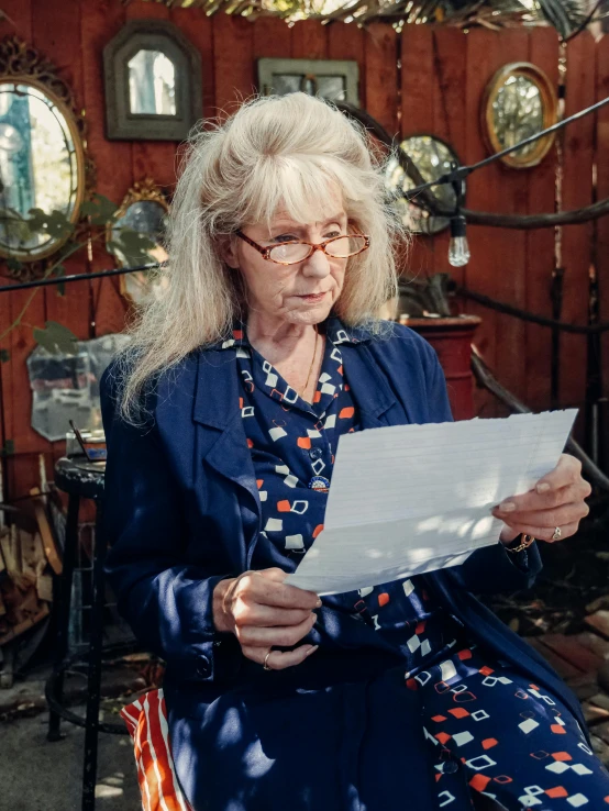 an elderly woman looks at papers in front of her