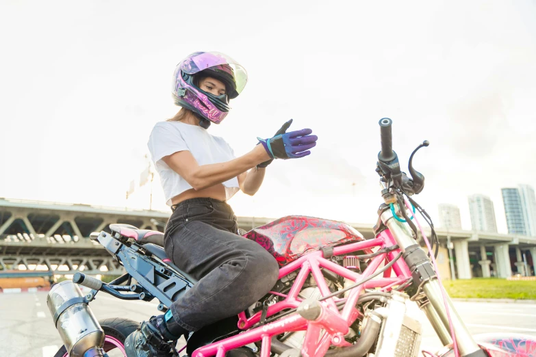 a person sitting on top of a pink and silver motorcycle