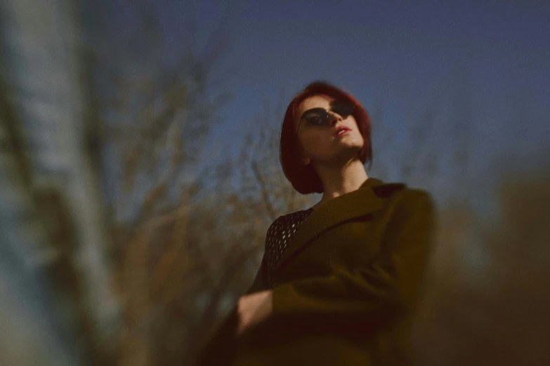 a young woman with red hair wearing sunglasses