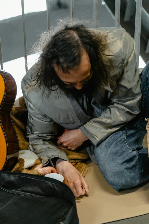 a man is sitting on the floor with a cat in his lap