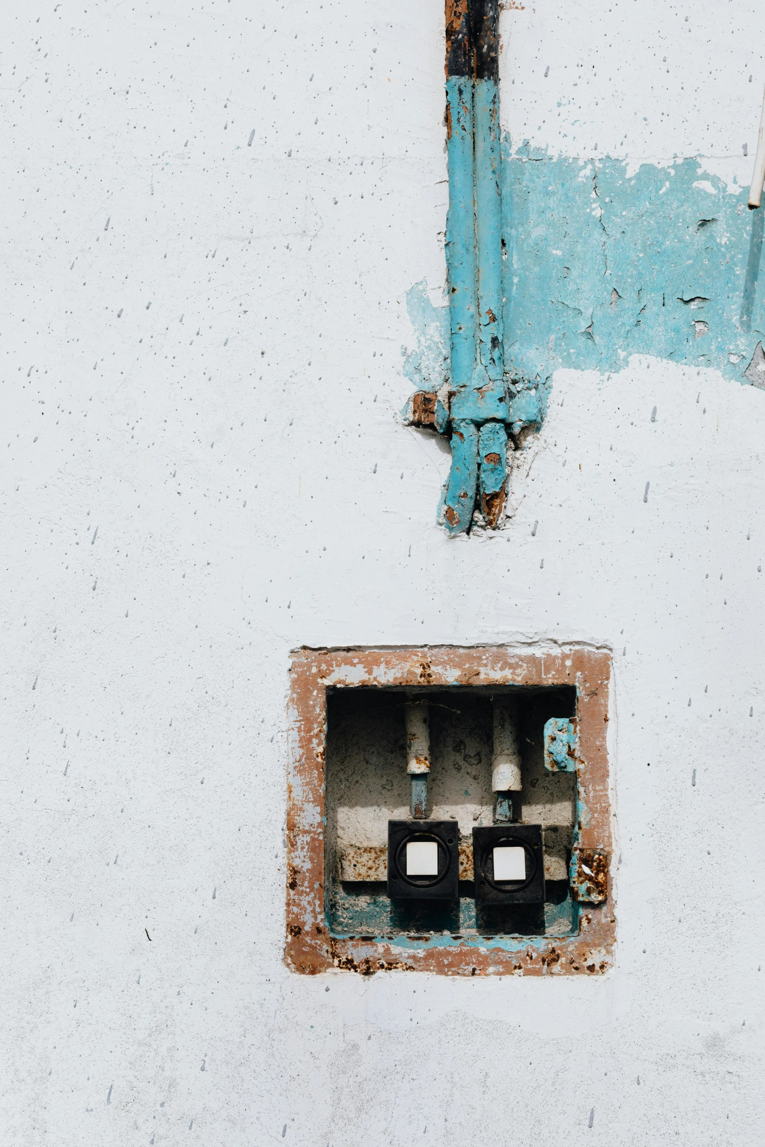 an old window with pipes on it with a blue handle