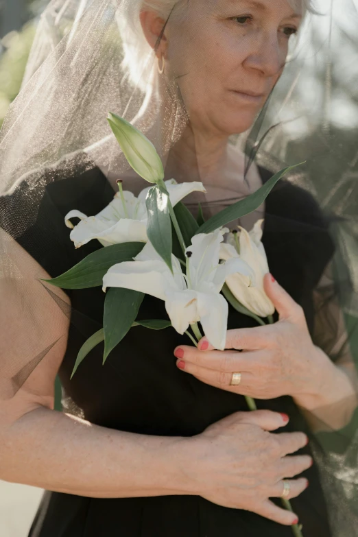 an older woman wearing a wedding veil and holding a bouquet of flowers