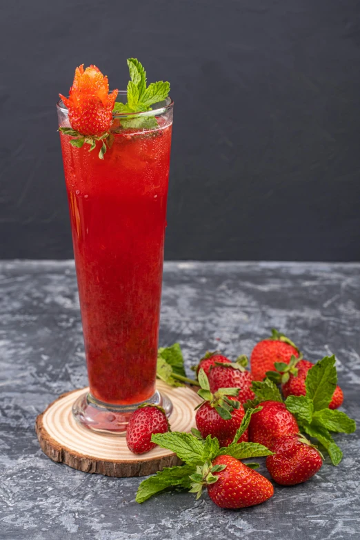 a glass of beverage with fresh strawberries on a table