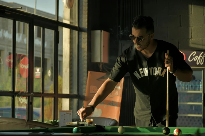 a man stands near a pool table in a shop