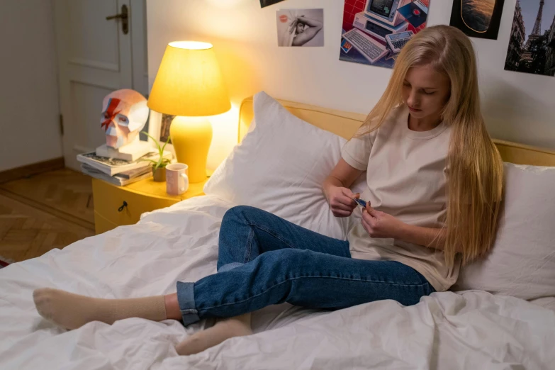 a girl sits on her bed with a stuffed animal