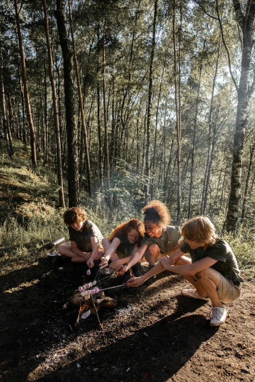 young people playing around a camp stove in the woods