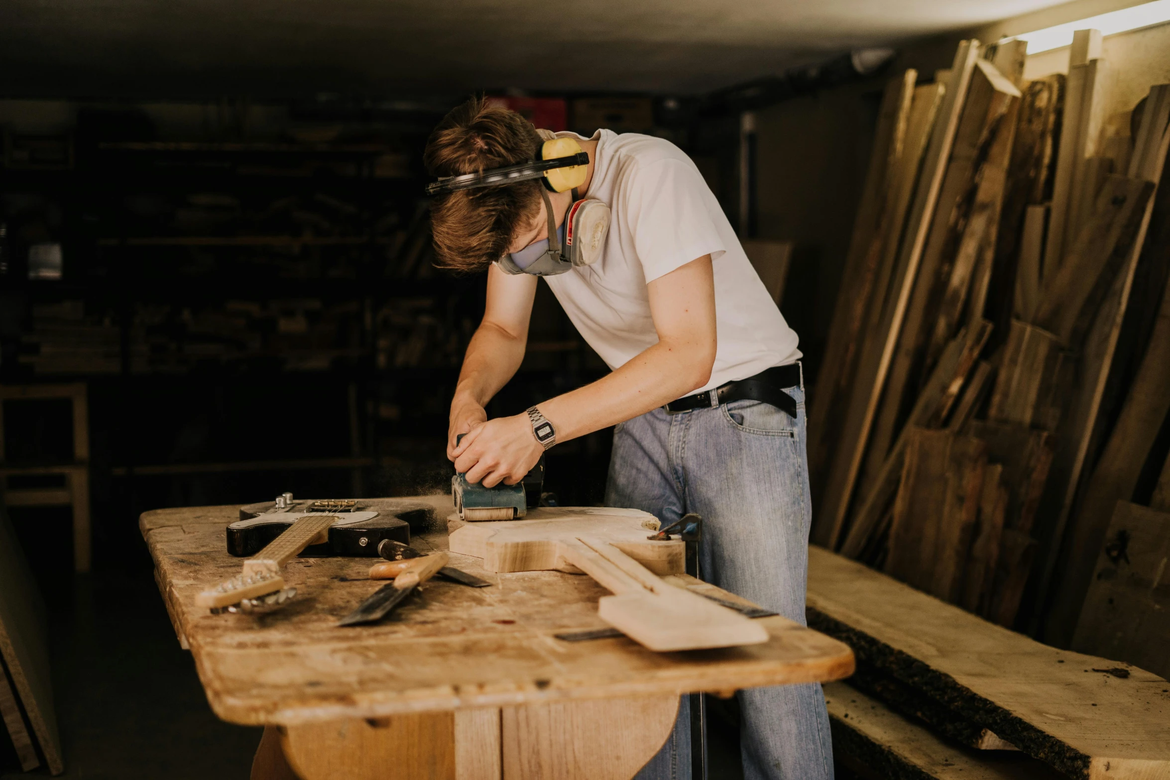 a man uses a planer to plane wood