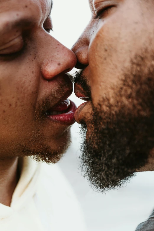 two people, one with a goatee, are kissing each other