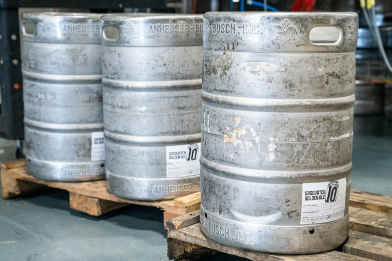 three metal barrels stacked on pallets in an industrial area