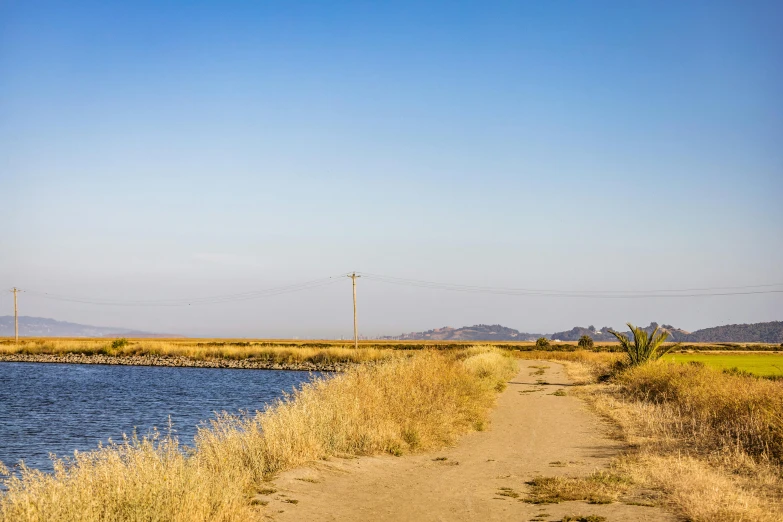 the water and dirt near the beach has a white boat