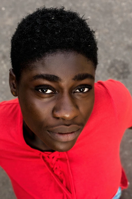 a young person standing with a red shirt and blue jeans