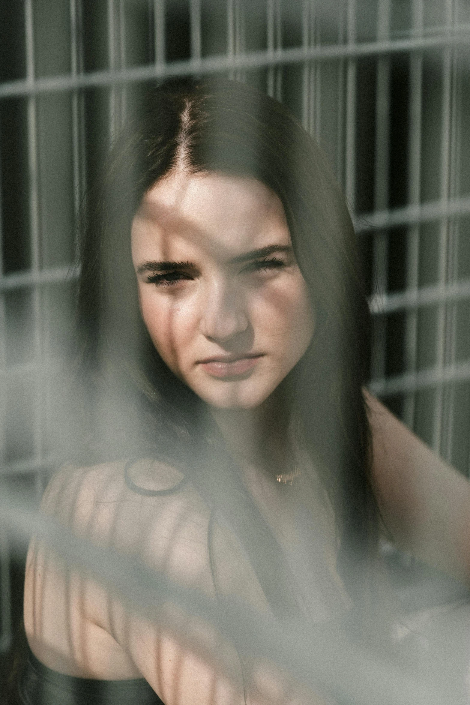 a woman looks in the mirror behind bars