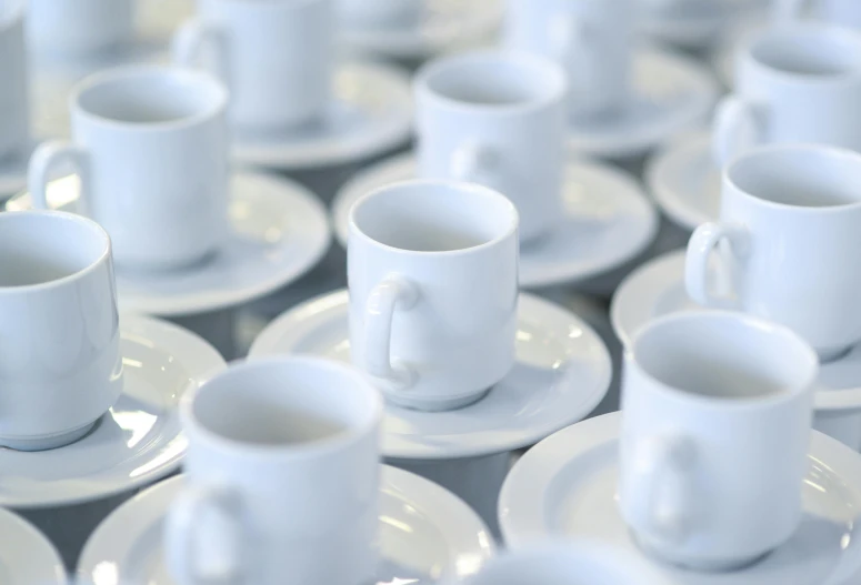 cups are arranged on plates together, all of which have been arranged in rows