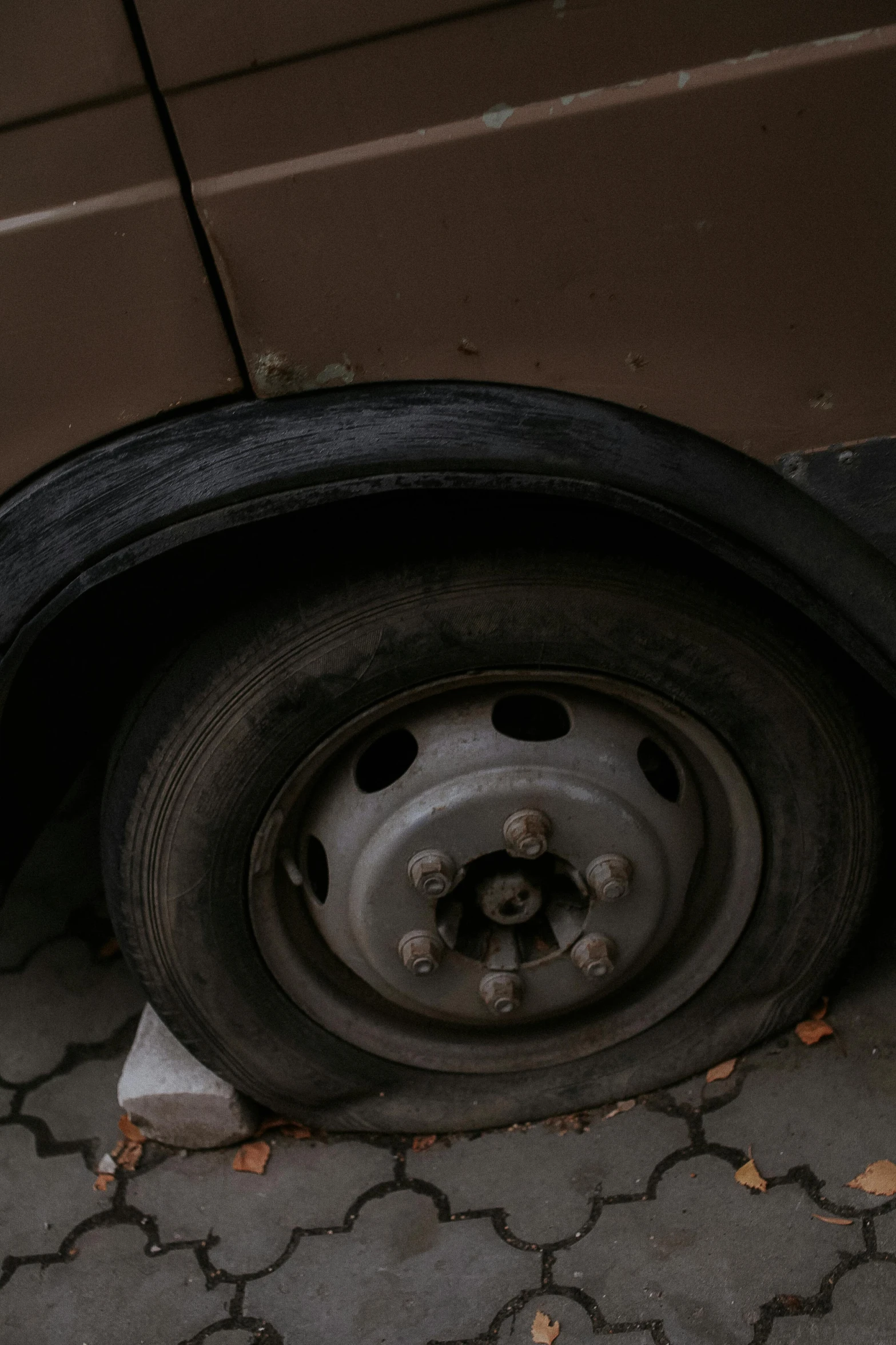 a tire sitting on a bricked area next to a building