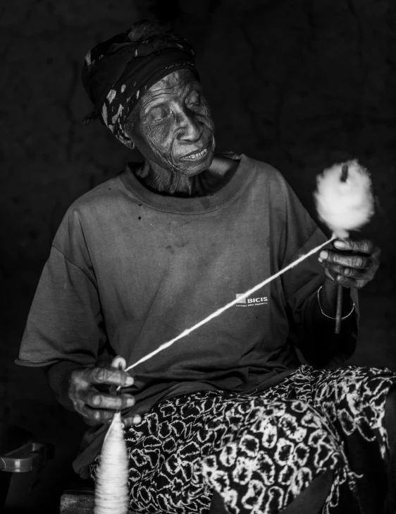 an old woman knitting a skeinish using a needle and hook