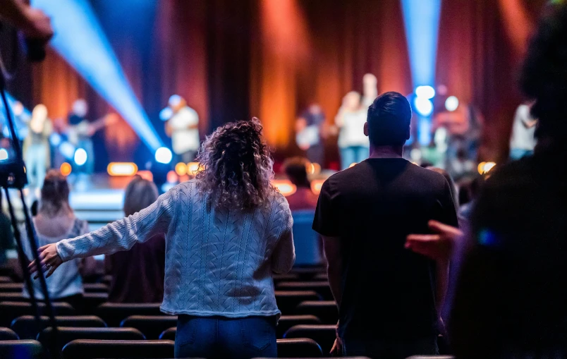 two people with their arms out in an auditorium