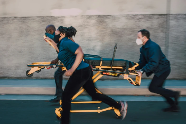 the two men are running along with each other carrying a cart