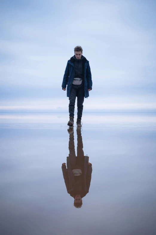 the man stands in the water and looks into the camera
