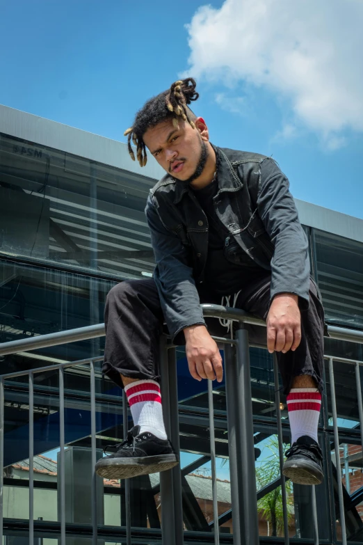 a man on a metal balcony has his hands on the railing