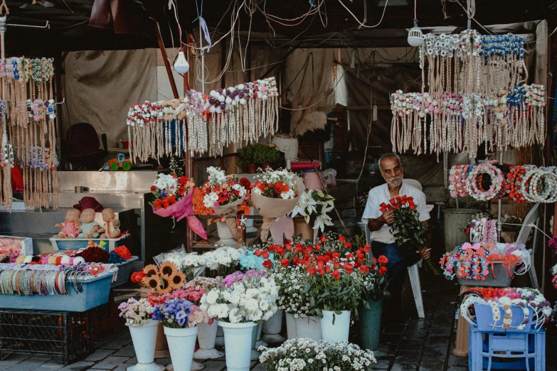 this is a man selling flowers in an outdoor market