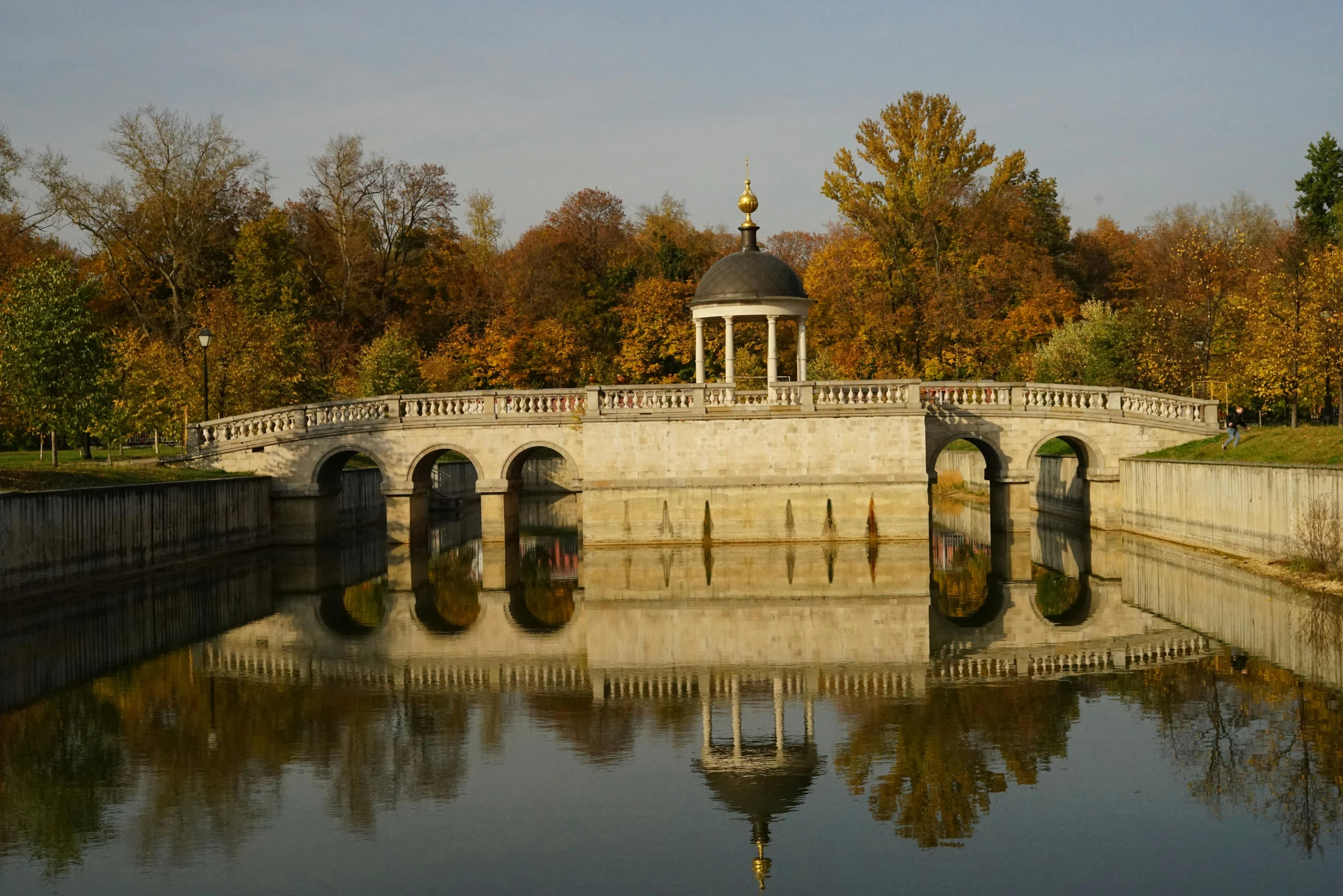 a bridge that is over water with trees in the background