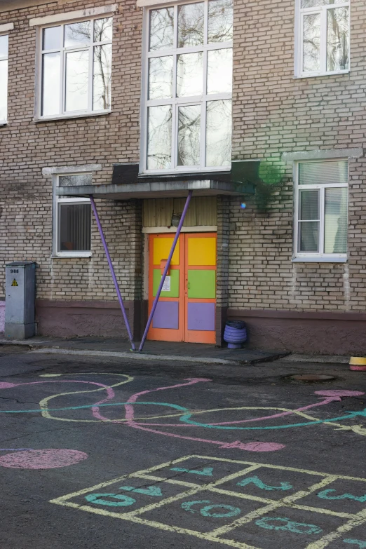 a child's play area with a rainbow colored door and chalk writing
