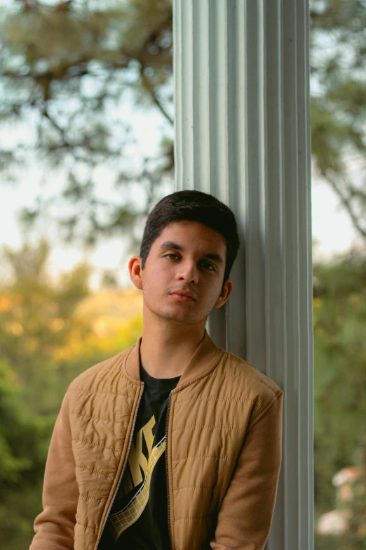 a man in a jacket is leaning against the pillars